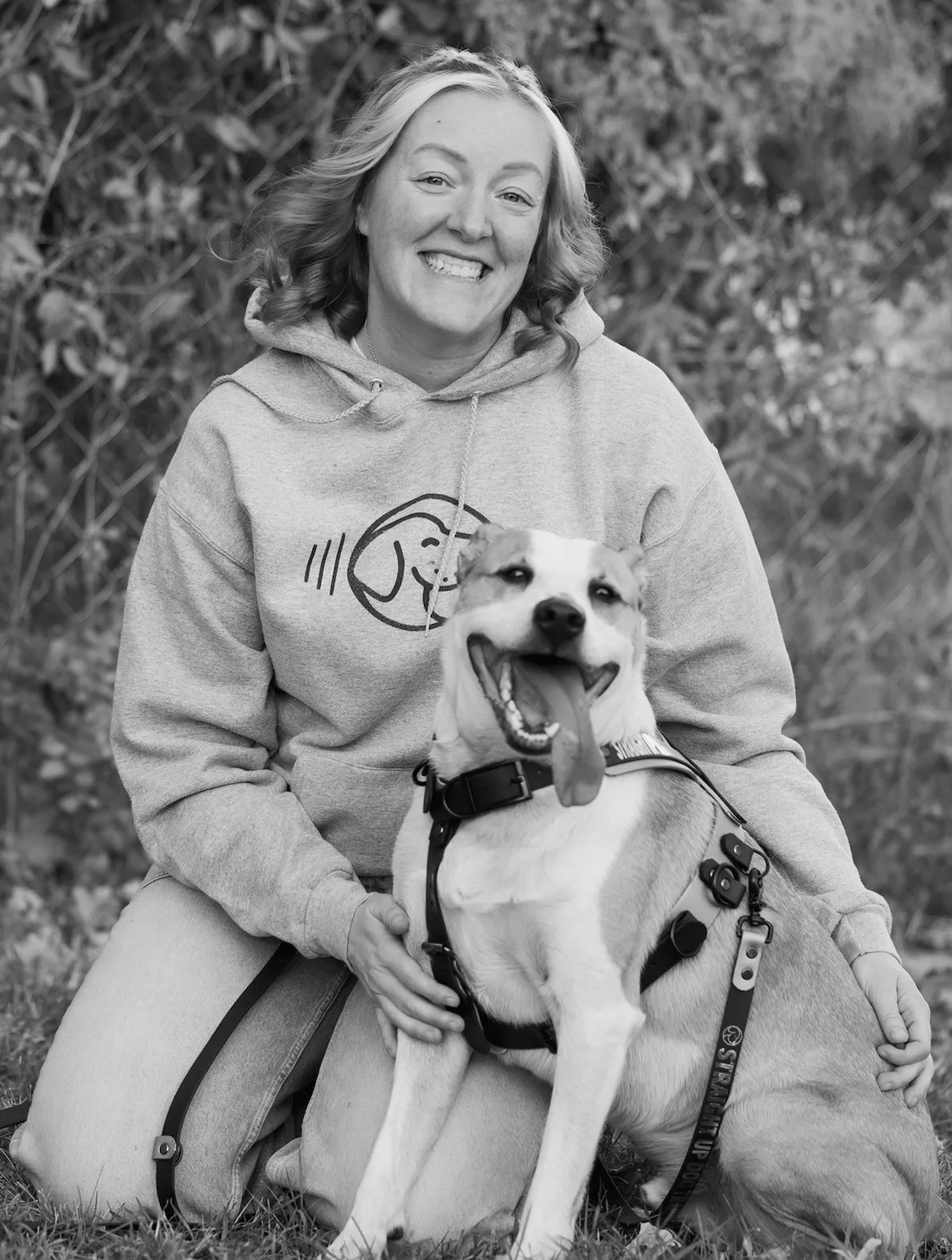 Woman in a hoodie with a dog outdoors