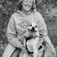 Woman in a hoodie with a dog outdoors