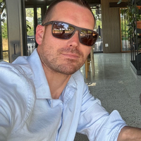Man wearing sunglasses and a light blue shirt in an indoor setting